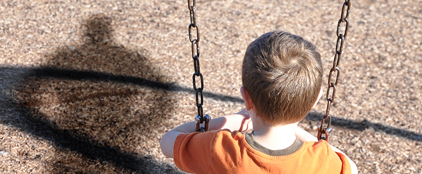 Back of child sitting on swing