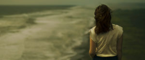 young woman staring out at ocean
