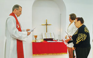 Pastor at altar with members