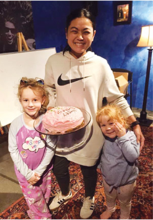 Thai woman and 2 small girls with birthday cake