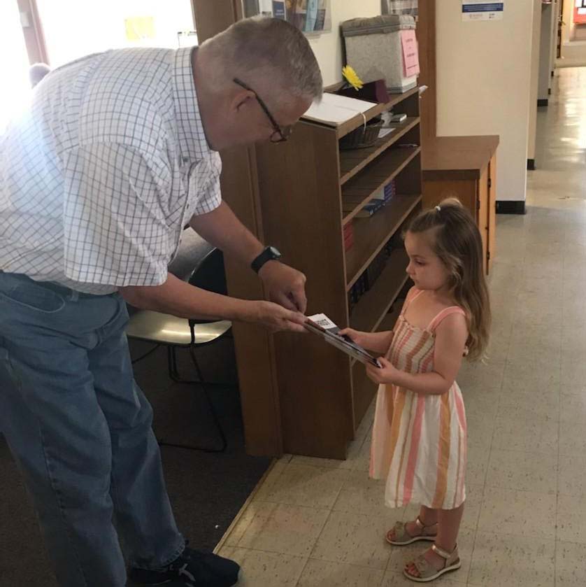 Three-year-old girl hands out Forward in Christ