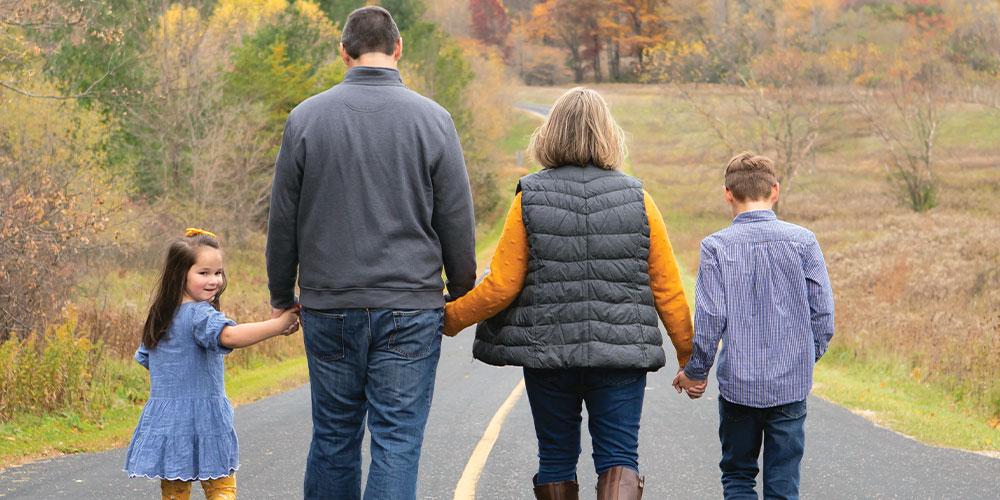 Family walking on road in fall