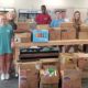 11 volunteers with boxes of food at a food pantry