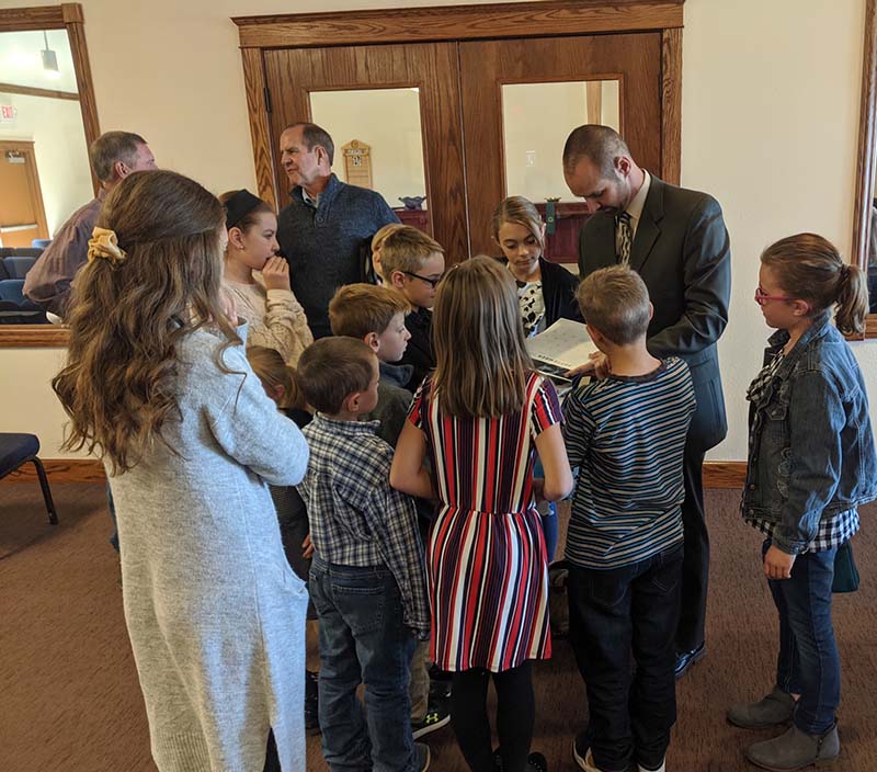 Pastor Matt Frey surrounded by children in the narthex