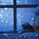 candle in window, looking out window to a snowy landscape