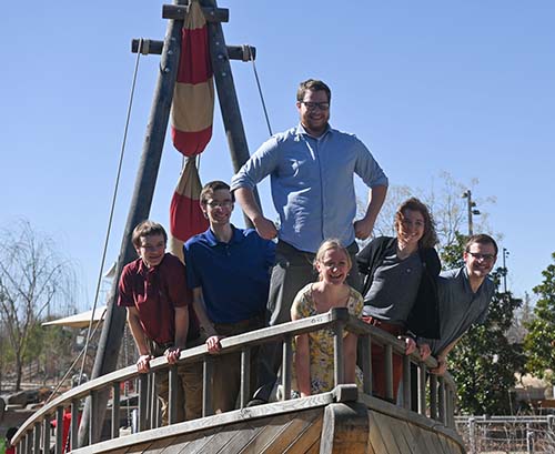 Six MLC students on the bow of a ship on a playground