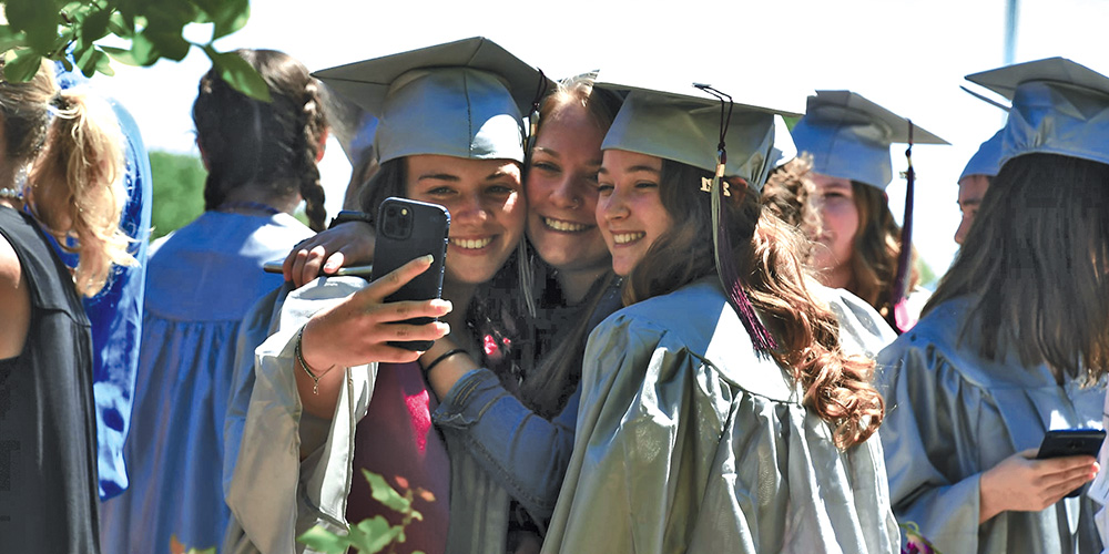 Photo of girls taking a self at graduation