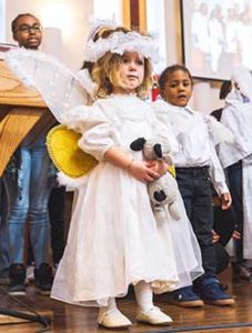 Children's Christmas program, young girl dressed as an angel
