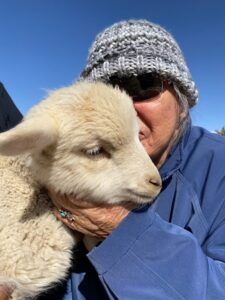 Marian Newman cuddling a lamb