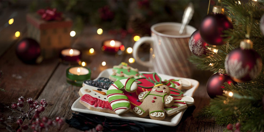 cookies and hot cocoa next to christmas decorations