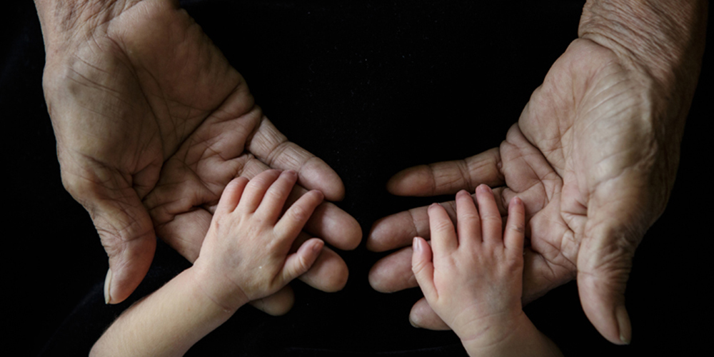 aging and baby hands together