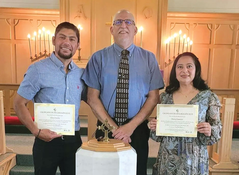 man and woman holding certificated with pastor