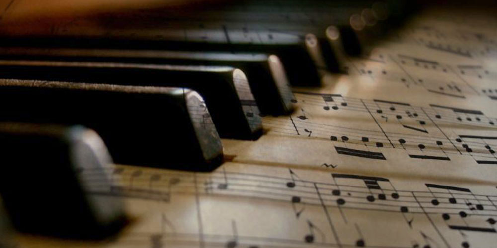 close up of piano keys and music sheets