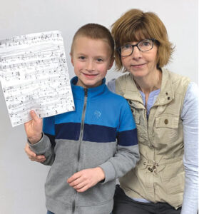 music teacher and student holding a sheet of music