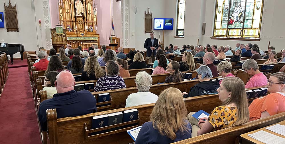 Rev. Donn Dobberstein presenting to people in pews at the Western Wisconsin District Sunday School Conference