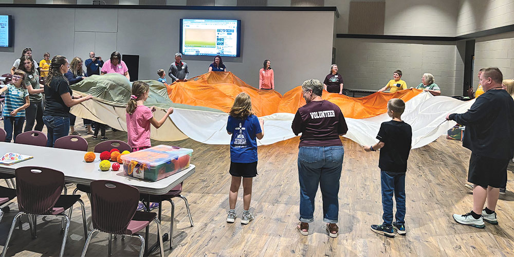 kids and adults playing with a large parachute