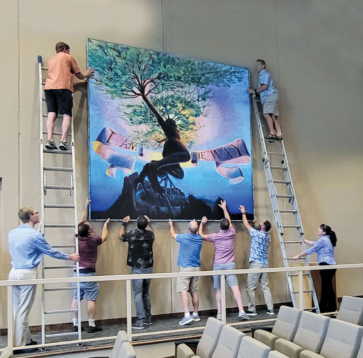 hanging large artwork men holding artwork and on ladders