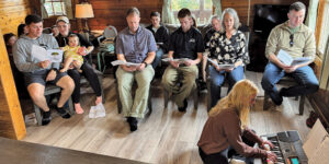 group sitting singing while girl plays electronic keyboard