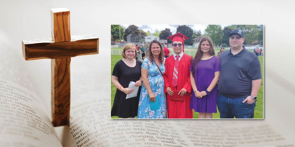 wooden cross and bible with photo of graduation and family members 2 girls a brother and mother