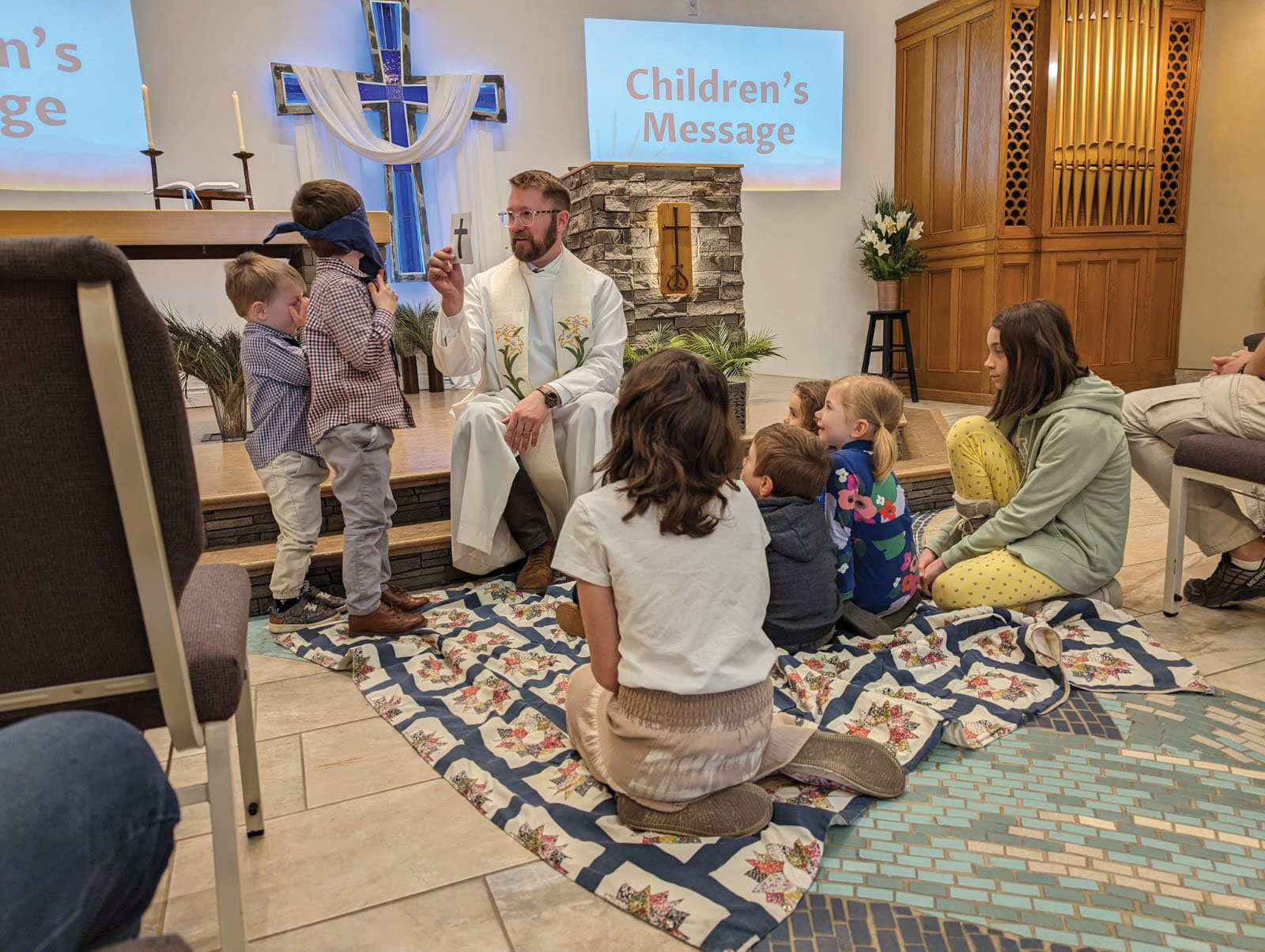 St. Peter, St. Albert, Alberta, Canada pastor taking to children sitting on the stairs of church easter