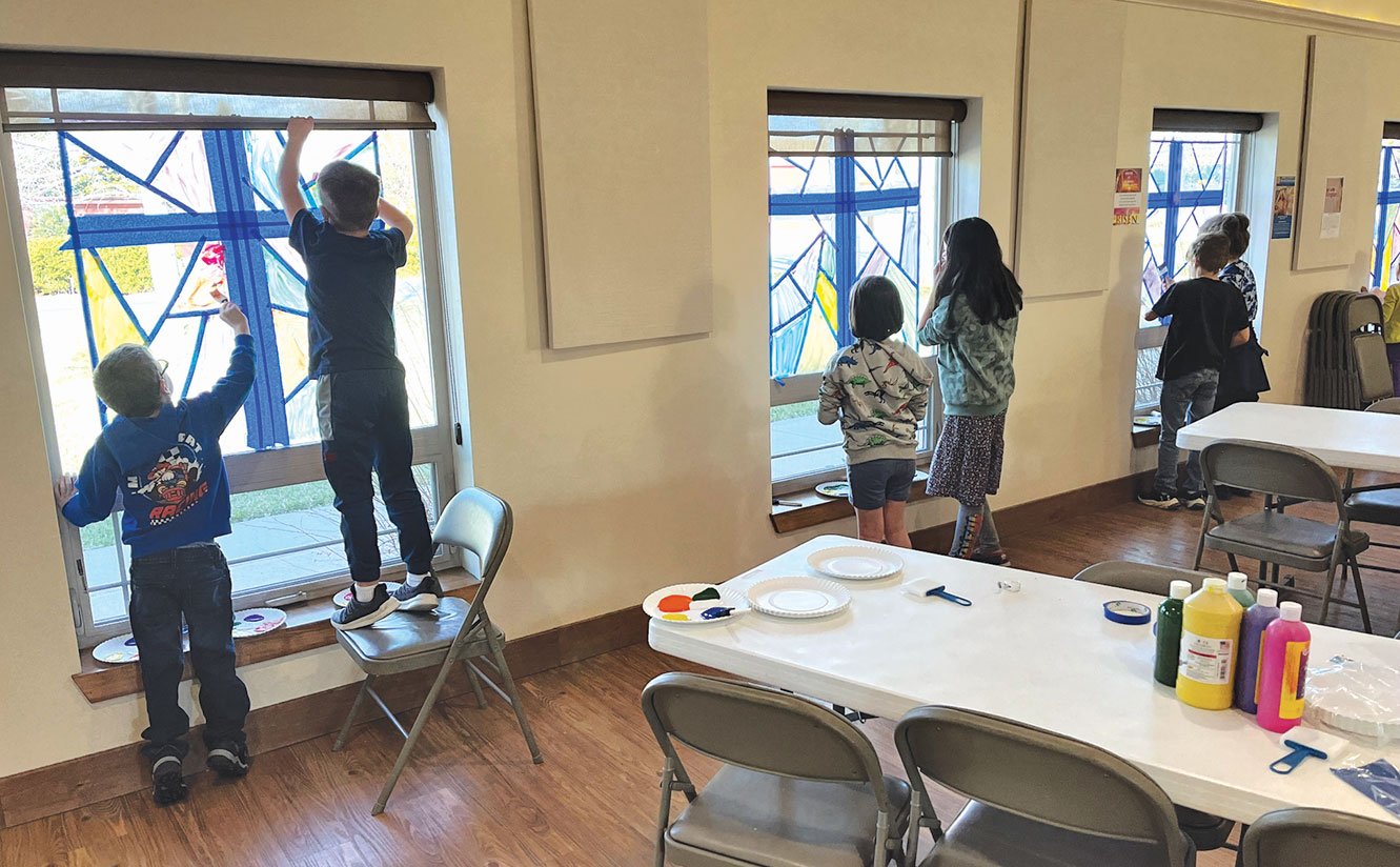 St. Peter, Fort Collins, Colo., Easter for Kids children painting stained glass on the windows of a building.