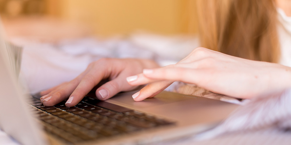 up close on womans hands usiing a computer