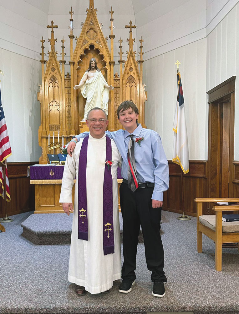 yound boy hugging pastor in front of church