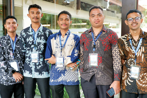 5 men in festive shirts with lanyards on