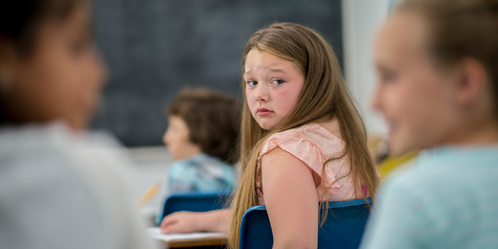 teen looking at other friends with anxiety bullying