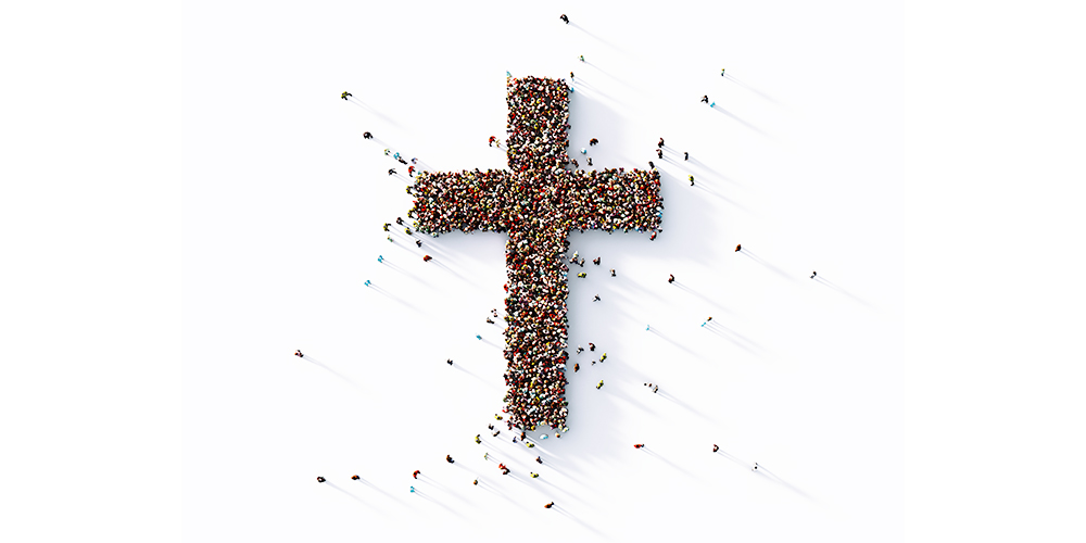 large amount of people standing in the shape of a cross