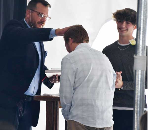 Man baptizing another man