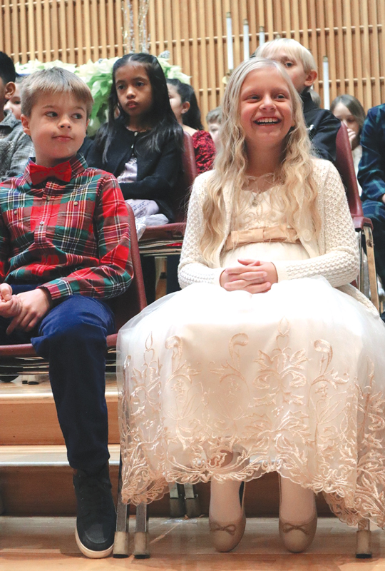boy and girl sitting at church service christmas