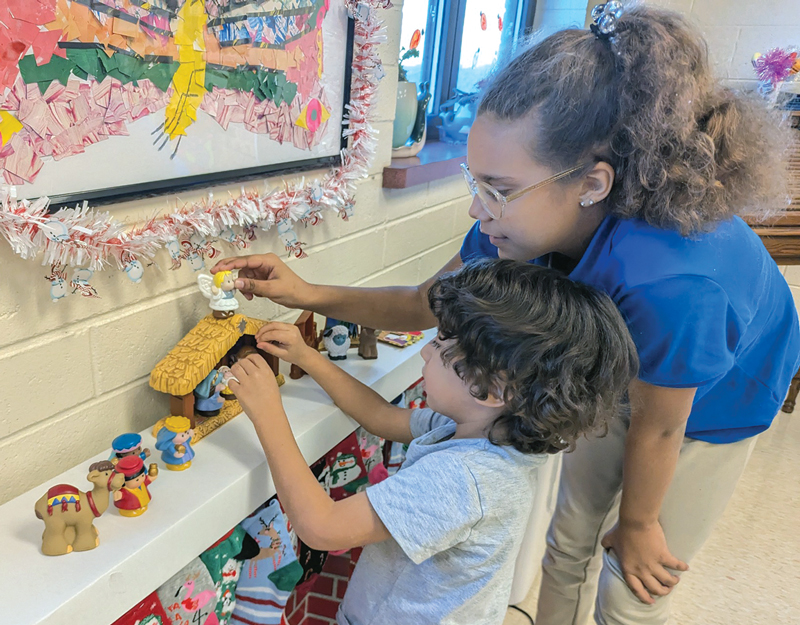 Girl and boy looking at fisher price nativity classroom