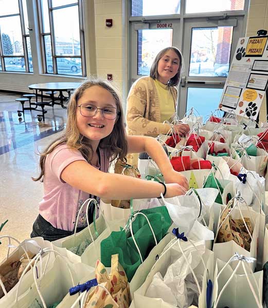 two girls assembling Christmas care packages