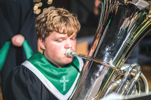 boy playing tuba green collar
