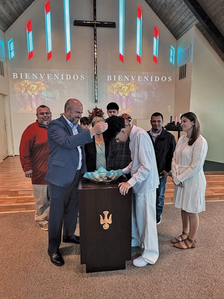 baptism of young man dressed in white