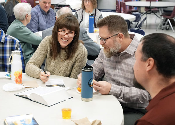 man and woman having conversation at table