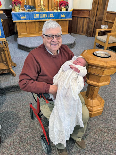 grandpa holding baby at baptism
