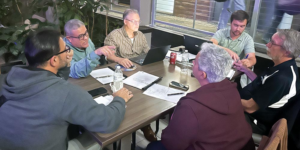 6 men chatting around a table
