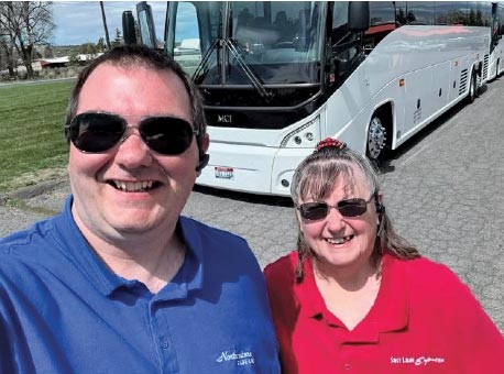 bus drivers standing in front of tour bus in blue and red shirts