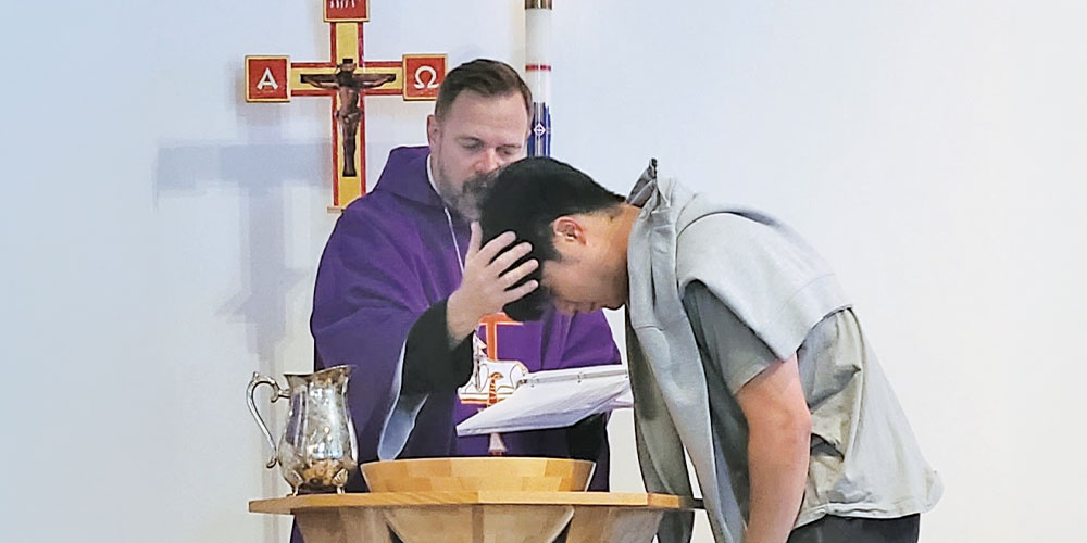 boy being baptized by pastor wearing purple