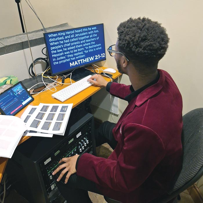 young man on computer burgandy suit coat