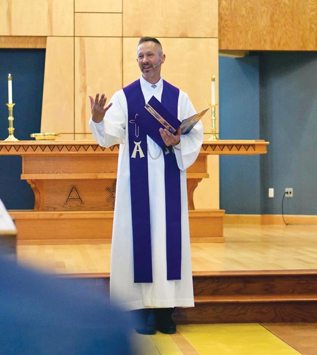 Pastor wearing purple stole in front of church