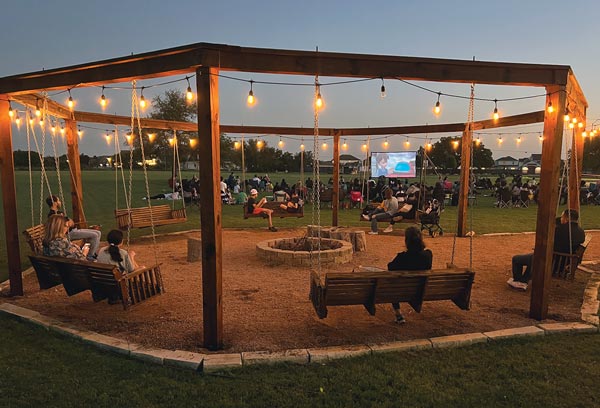 outdoor swings and firepit with movie playing