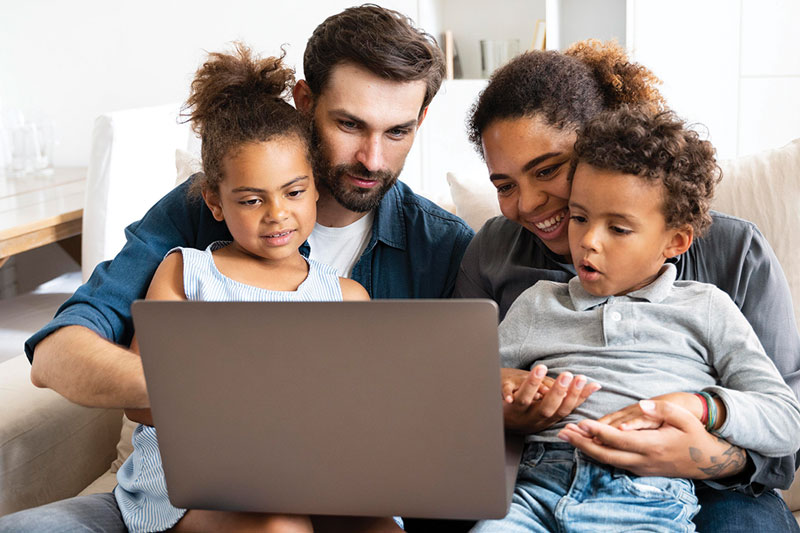 parents looking at computer with kids sitting on lap