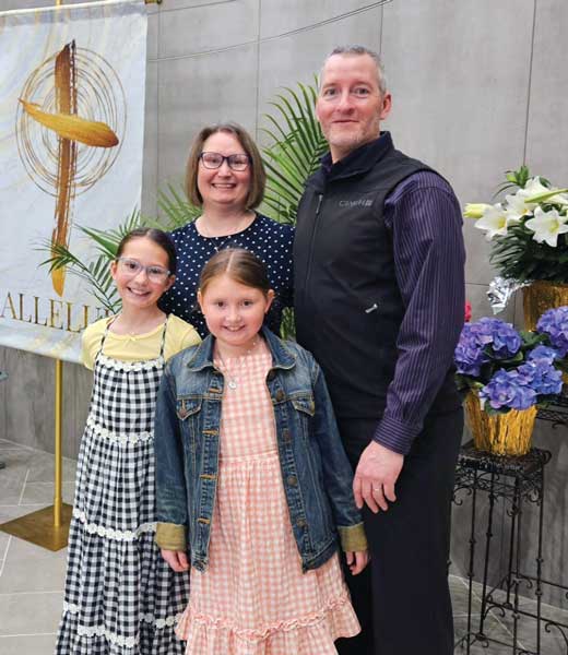 family posing for photo in front of church easter lily