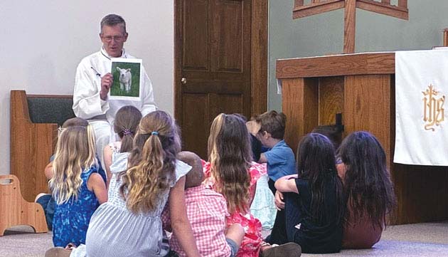 children's service pastor showing lamb to kids