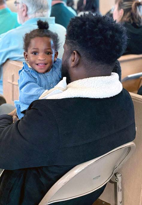 man holding his daughter smiling in church