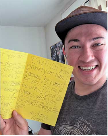 Man holding up a yellow homemade card