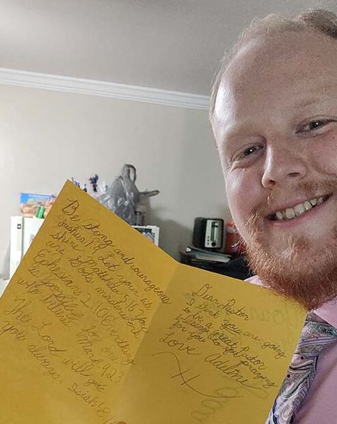 Caleb Foelske with encouraging card from young student upon his graduation from the seminary